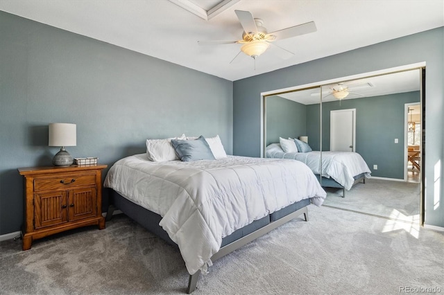 carpeted bedroom featuring a closet, baseboards, and ceiling fan