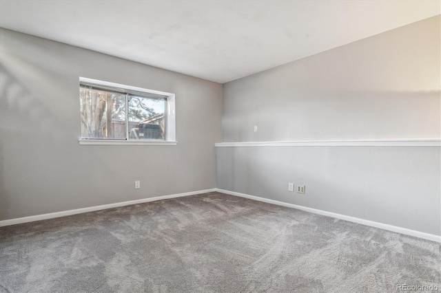 spare room with baseboards and carpet floors