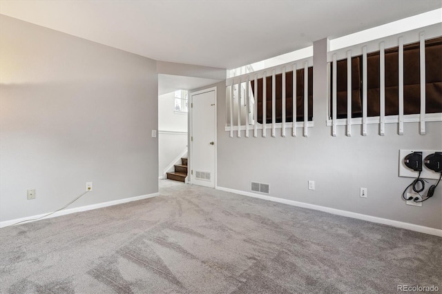 empty room featuring visible vents, baseboards, stairs, and carpet