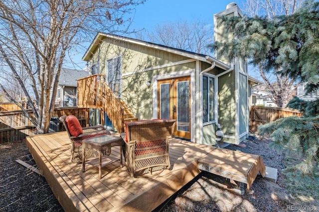 rear view of property with fence and a wooden deck