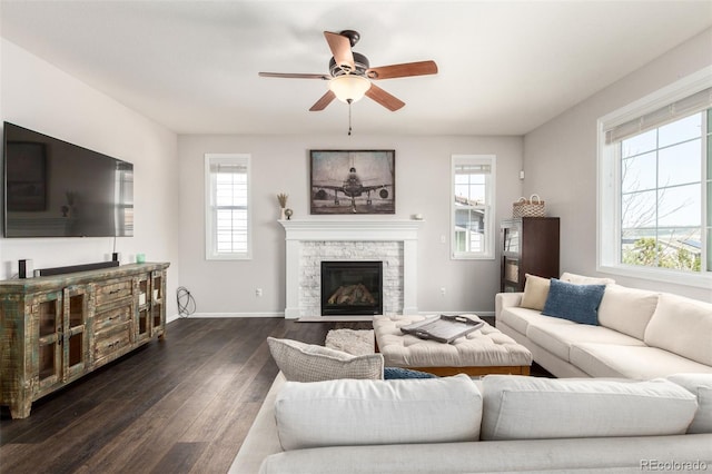 2881 Black Canyon Way, Castle Rock, CO 80109 - living room featuring a ceiling fan, baseboards, a stone fireplace, and dark wood finished floors