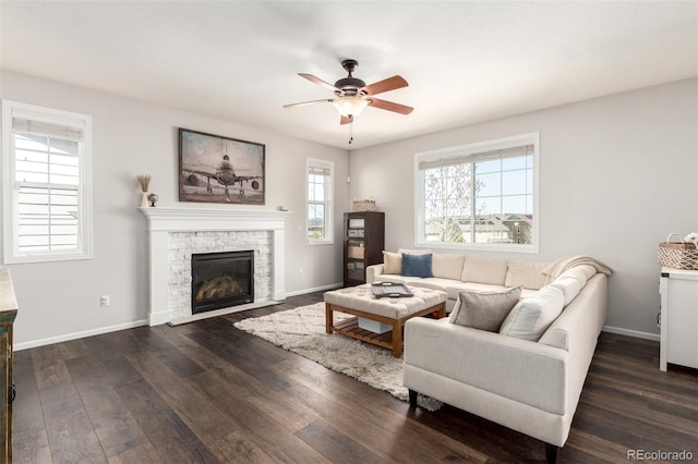 2881 Black Canyon Way, Castle Rock, CO 80109 - living room featuring baseboards, a stone fireplace, dark wood-style floors, and ceiling fan