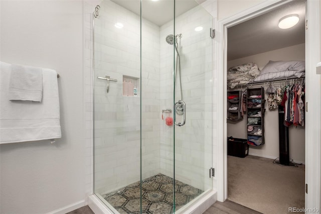 2881 Black Canyon Way, Castle Rock, CO 80109 - bathroom featuring a shower stall, baseboards, wood finished floors, and a spacious closet