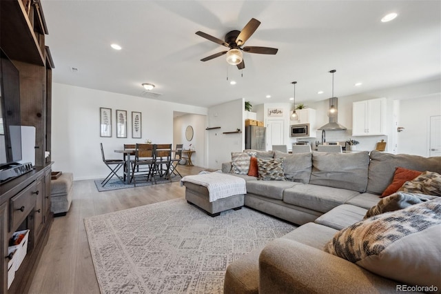 living room with light wood-type flooring, ceiling fan, baseboards, and recessed lighting