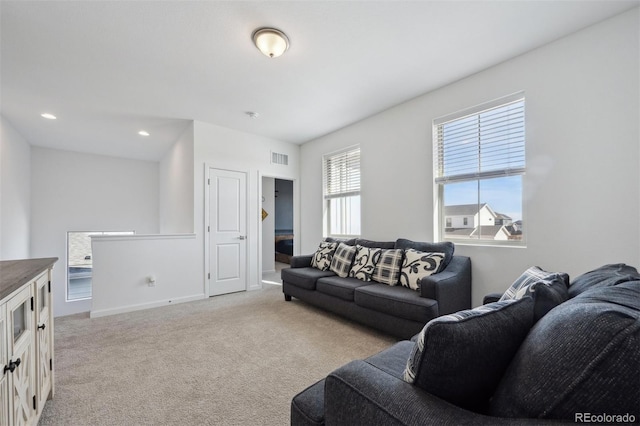 living room featuring light carpet, baseboards, visible vents, and recessed lighting