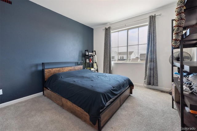 bedroom featuring baseboards and light colored carpet