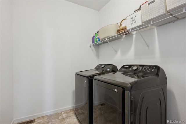 laundry area with laundry area, washing machine and clothes dryer, visible vents, and baseboards