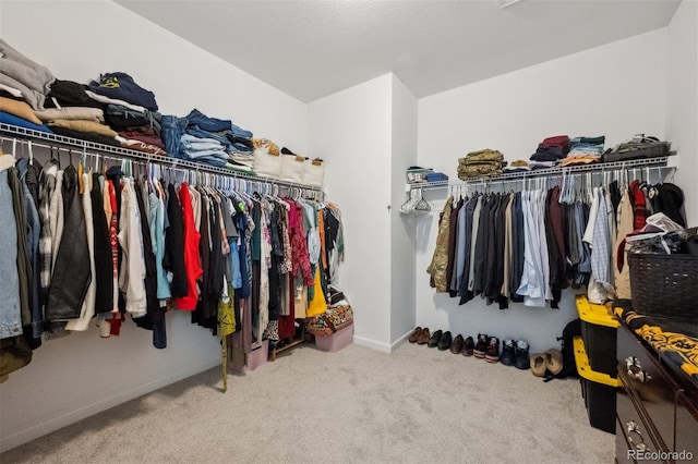 spacious closet featuring light colored carpet