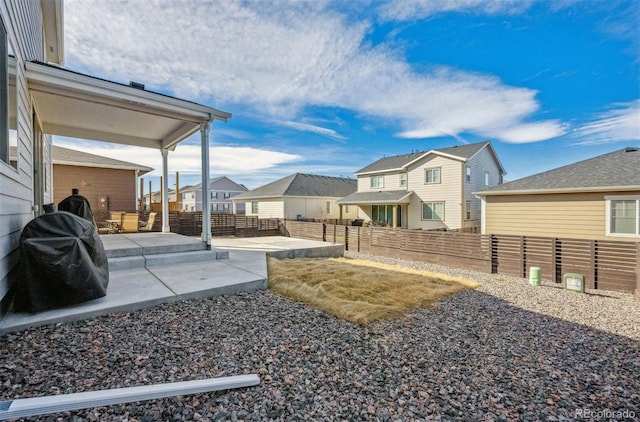 view of yard featuring a residential view, a fenced backyard, and a patio