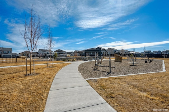 view of property's community featuring a residential view, fence, and a yard