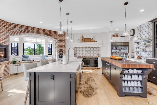 15355 Zuni St, Broomfield, CO 80023 - kitchen with open shelves, a spacious island, butcher block countertops, a sink, and recessed lighting