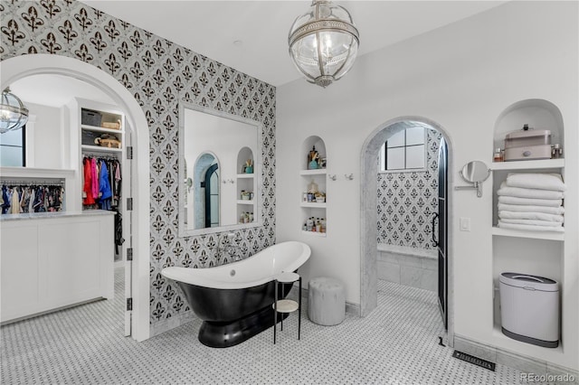 15355 Zuni St, Broomfield, CO 80023 - bathroom featuring wallpapered walls, tiled shower, a freestanding tub, baseboards, and a walk in closet