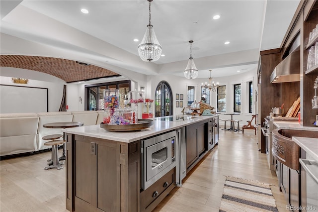 15355 Zuni St, Broomfield, CO 80023 - kitchen featuring a chandelier, stainless steel microwave, recessed lighting, light countertops, and a large island with sink