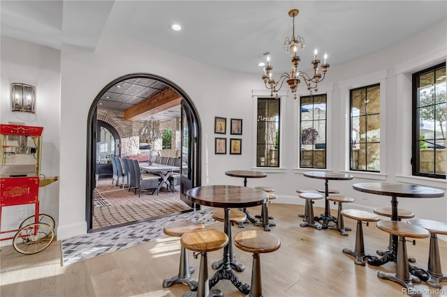 15355 Zuni St, Broomfield, CO 80023 - dining area featuring light wood finished floors, a chandelier, recessed lighting, baseboards, and arched walkways