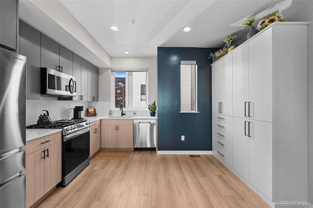 3101 W 47th Ave Unit 13, Denver, CO 80211 - kitchen featuring stainless steel appliances, a sink, light wood-style flooring, light countertops, and recessed lighting