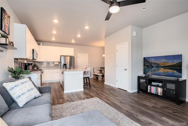 living room featuring dark hardwood / wood-style flooring and ceiling fan