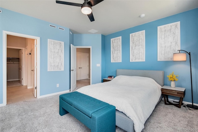 bedroom with carpet floors, a walk in closet, ceiling fan, and a closet