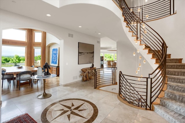 2421 Ranch Reserve Rdg, Denver, CO 80234 - foyer featuring arched walkways, recessed lighting, stairs, inlaid floor details, and a chandelier
