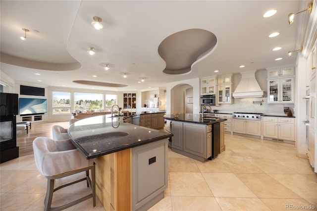 2421 Ranch Reserve Rdg, Denver, CO 80234 - kitchen with a spacious island, premium range hood, gas cooktop, tasteful backsplash, and recessed lighting