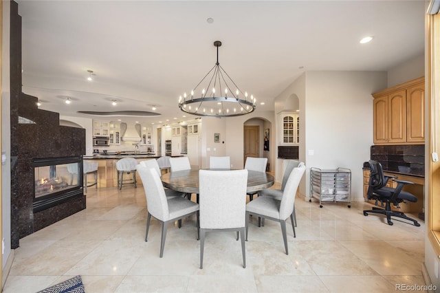 2421 Ranch Reserve Rdg, Denver, CO 80234 - dining room with arched walkways, recessed lighting, an office area, and a chandelier