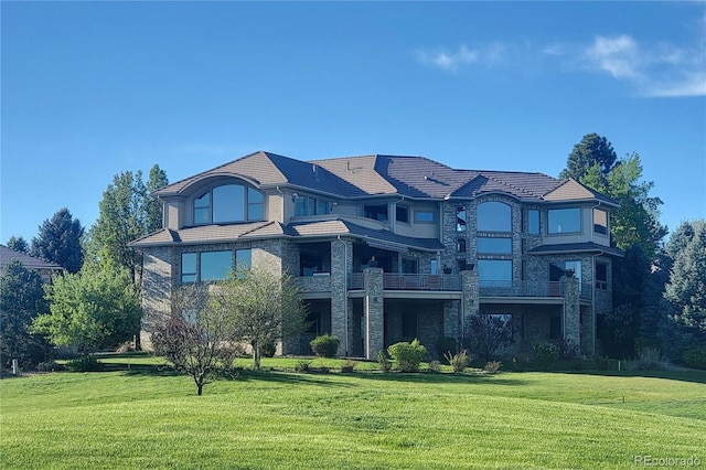 2421 Ranch Reserve Rdg, Denver, CO 80234 - back of house with a lawn, stone siding, and a balcony