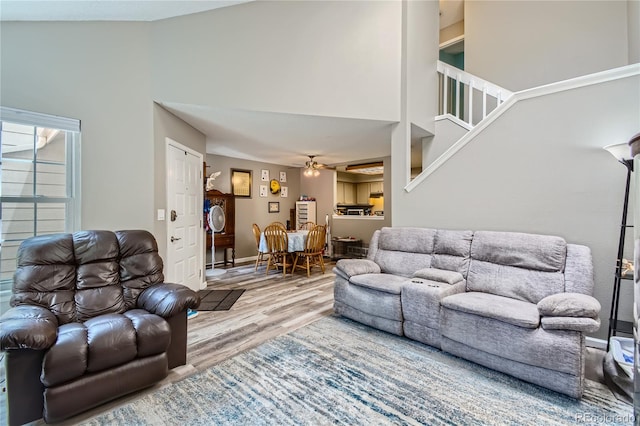 living room featuring high vaulted ceiling, ceiling fan, and light hardwood / wood-style floors