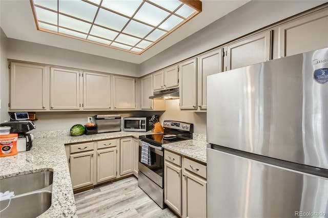 7370 E Florida Ave Unit 1020, Denver, CO 80231 - kitchen featuring appliances with stainless steel finishes, under cabinet range hood, light wood-style flooring, light stone countertops, and a sink