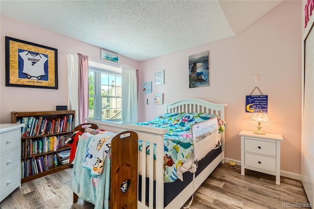 7370 E Florida Ave Unit 1020, Denver, CO 80231 - bedroom featuring wood finished floors, a textured ceiling, and baseboards