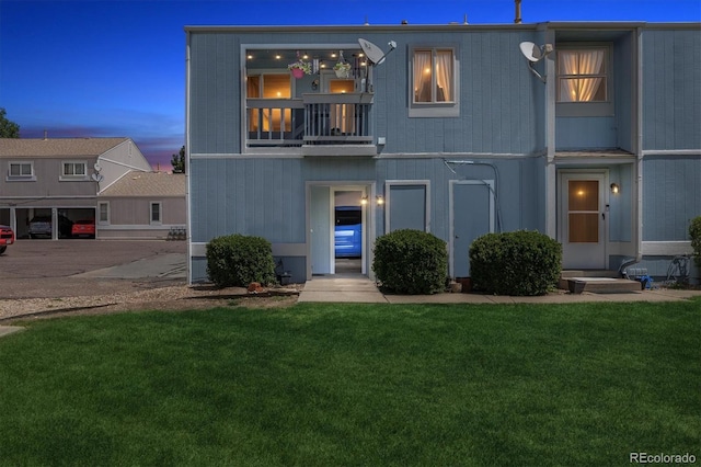 view of front of property with a yard and a balcony