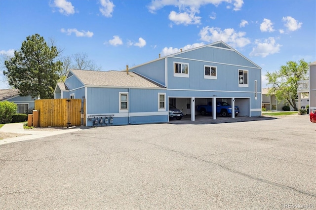 view of building exterior featuring fence and a garage