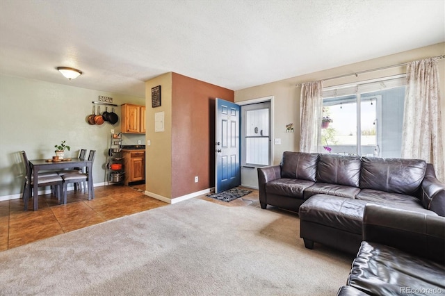 living area with light tile patterned floors, baseboards, a textured ceiling, and light colored carpet
