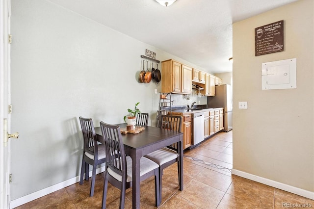 dining space featuring light tile patterned flooring, baseboards, and electric panel