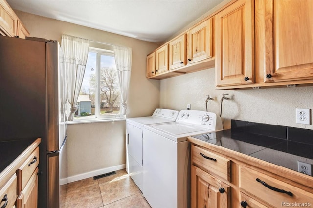clothes washing area featuring laundry area, visible vents, light tile patterned flooring, washer and dryer, and baseboards