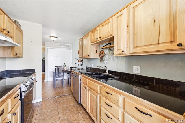 kitchen featuring light brown cabinetry, stainless steel appliances, under cabinet range hood, and a sink