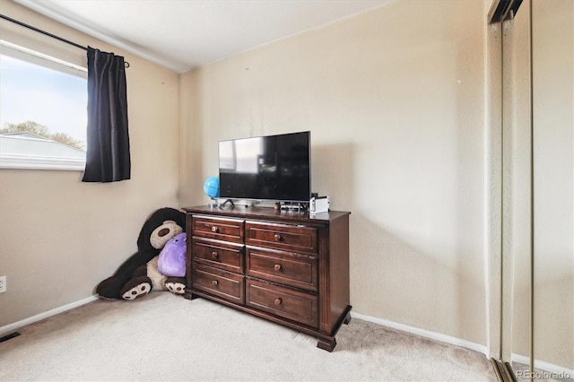 bedroom featuring baseboards and light carpet