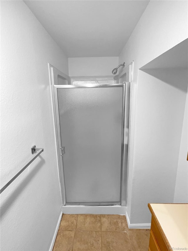 bathroom featuring walk in shower, vanity, and tile patterned flooring