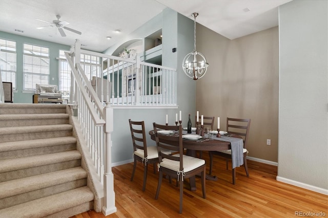 dining room with hardwood / wood-style flooring and ceiling fan with notable chandelier