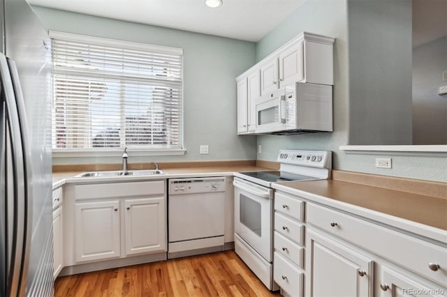 kitchen featuring sink, white appliances, white cabinets, and light wood-type flooring