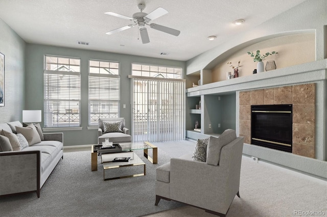 9818 E Carolina Pl, Aurora, CO 80247 - living area with carpet floors, baseboards, a ceiling fan, a fireplace, and a textured ceiling