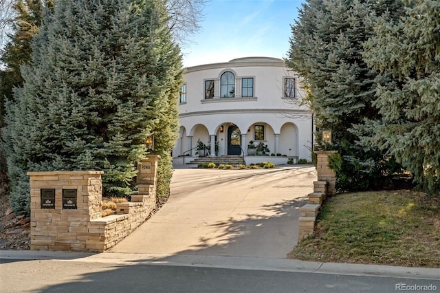 view of front of property featuring covered porch, driveway, and stucco siding