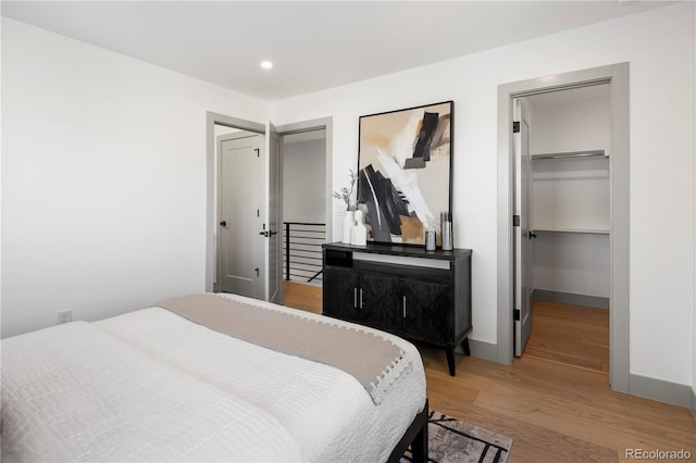 bedroom with wood-type flooring, a closet, and a walk in closet