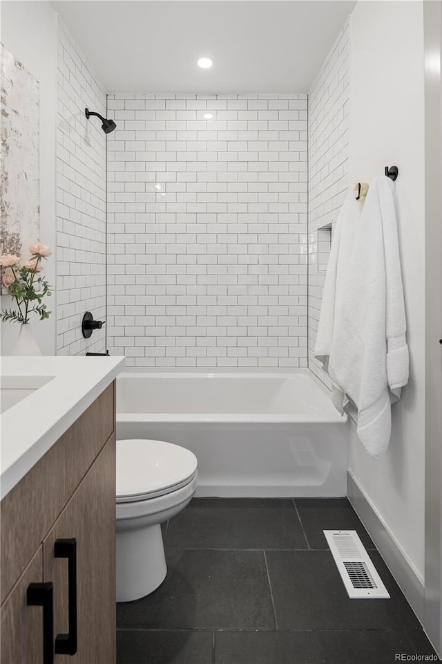 full bathroom featuring toilet, vanity, tiled shower / bath combo, and tile patterned flooring