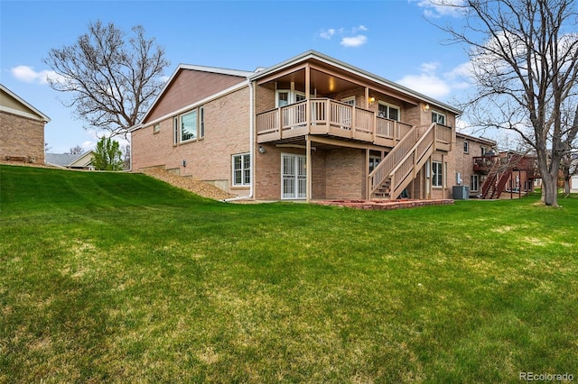 rear view of property featuring a wooden deck, a yard, stairway, and brick siding