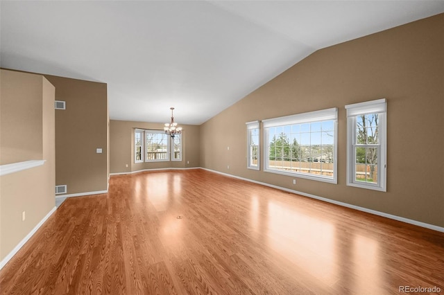 interior space featuring visible vents, lofted ceiling, wood finished floors, and a notable chandelier