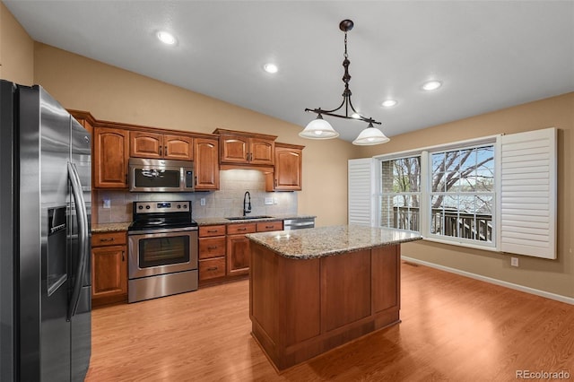 kitchen featuring brown cabinets, a sink, stainless steel appliances, backsplash, and a kitchen island