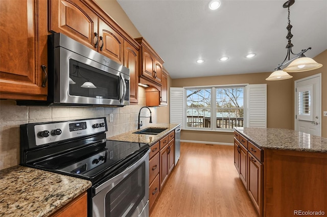 kitchen with decorative backsplash, a sink, light wood-style floors, stainless steel appliances, and recessed lighting
