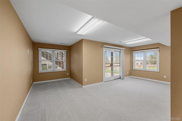 unfurnished room with baseboards and light carpet