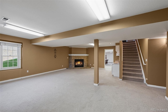 basement with baseboards, light carpet, a brick fireplace, and visible vents