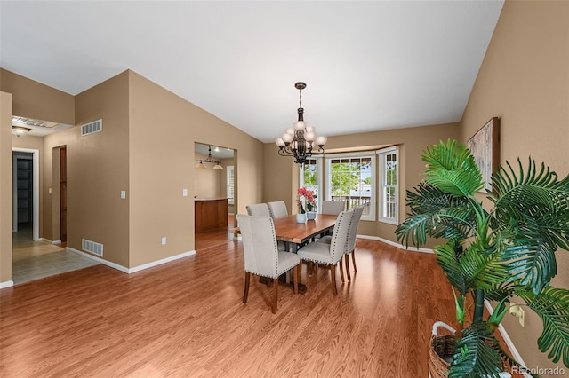 4927 Greenwich Way, Highlands Ranch, CO 80130 - dining space featuring a chandelier, light wood-style floors, and vaulted ceiling