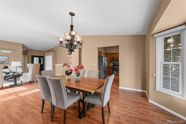 4927 Greenwich Way, Highlands Ranch, CO 80130 - dining room with vaulted ceiling, a chandelier, and light wood-style floors
